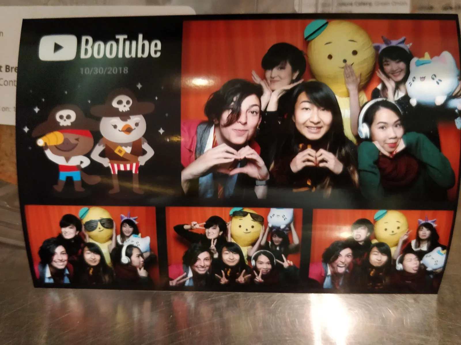 A 'BooTube' Halloween photo-booth strip from 2018: the team making heart hands with plush YouTube mascots